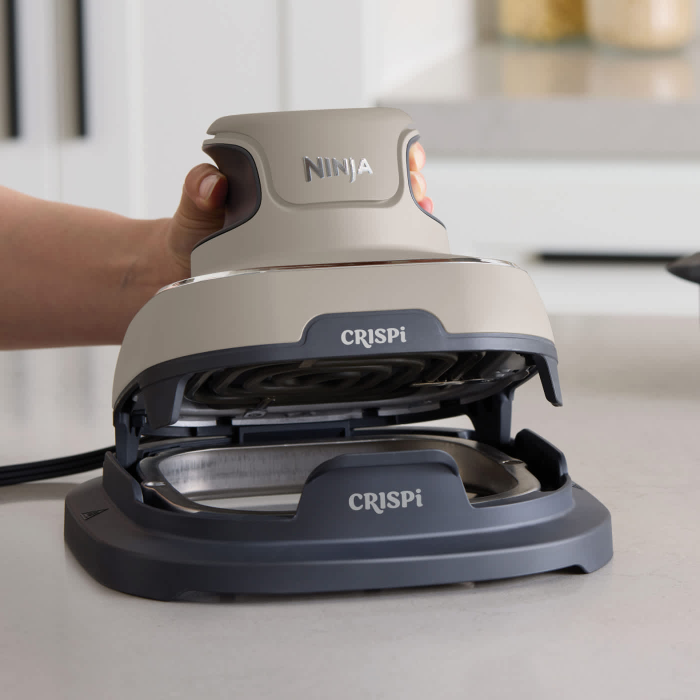 Personne fixant le support de protection anti-chaleur sur la base de la Ninja Crispi