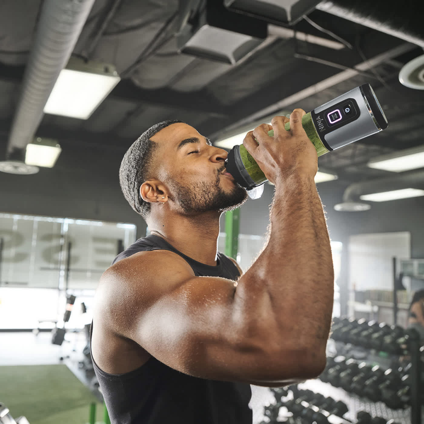 personne buvant depuis le blender portable Ninja dans une salle de sport.