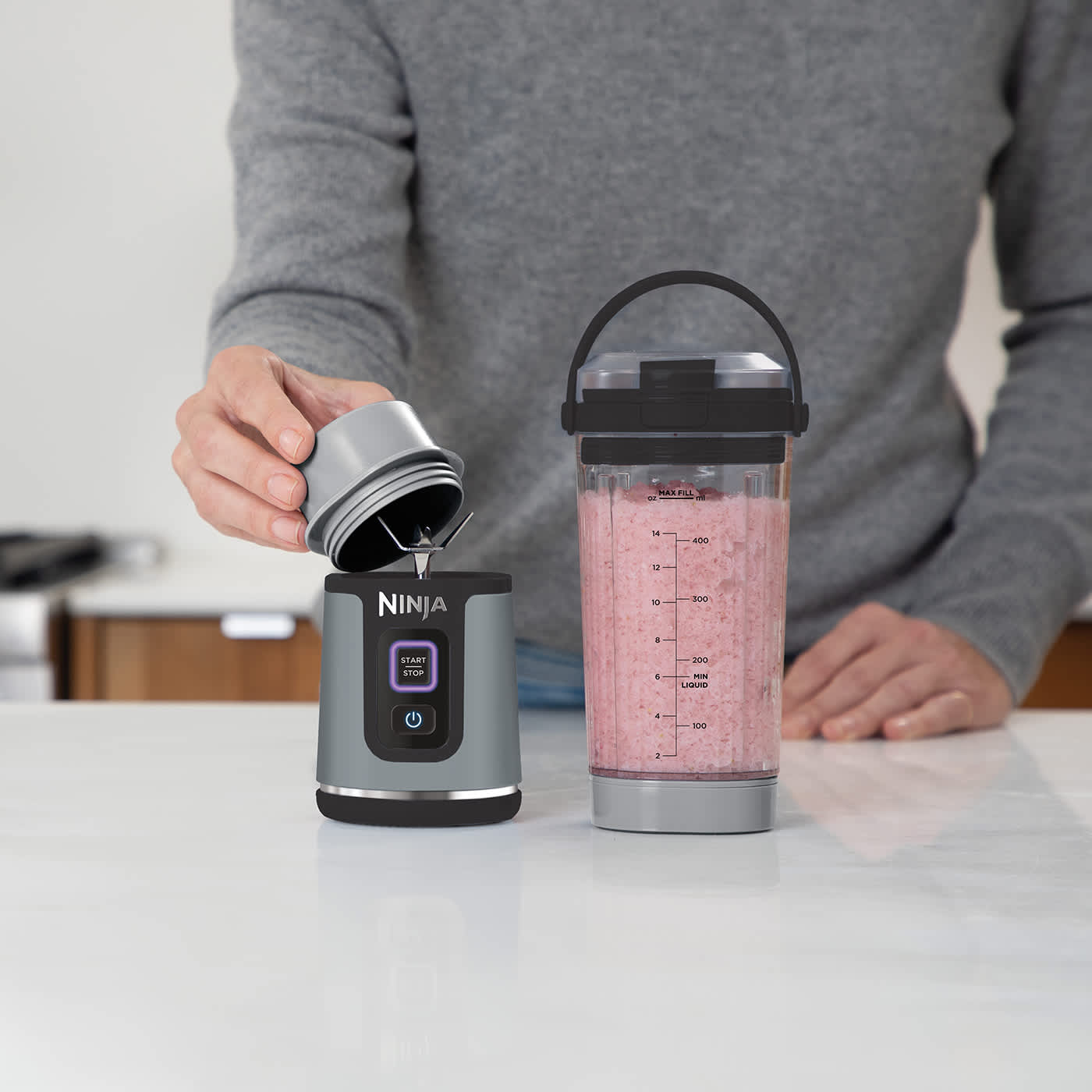 personne buvant depuis le blender portable Ninja dans une salle de sport.