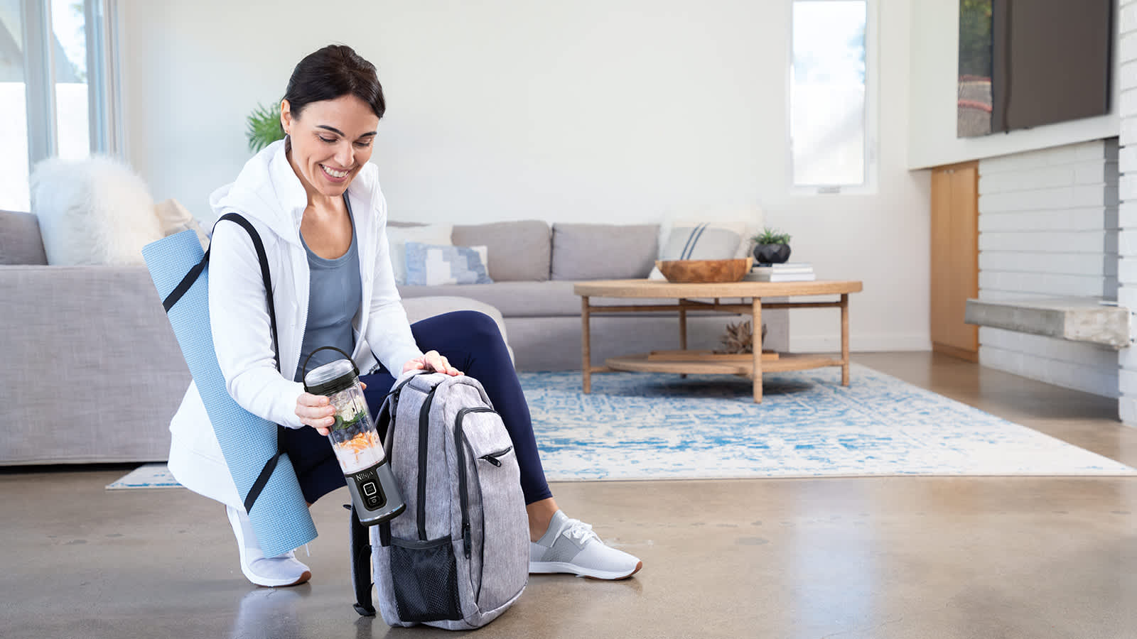 Personne mettant le blender portable Ninja dans un sac &agrave; dos.