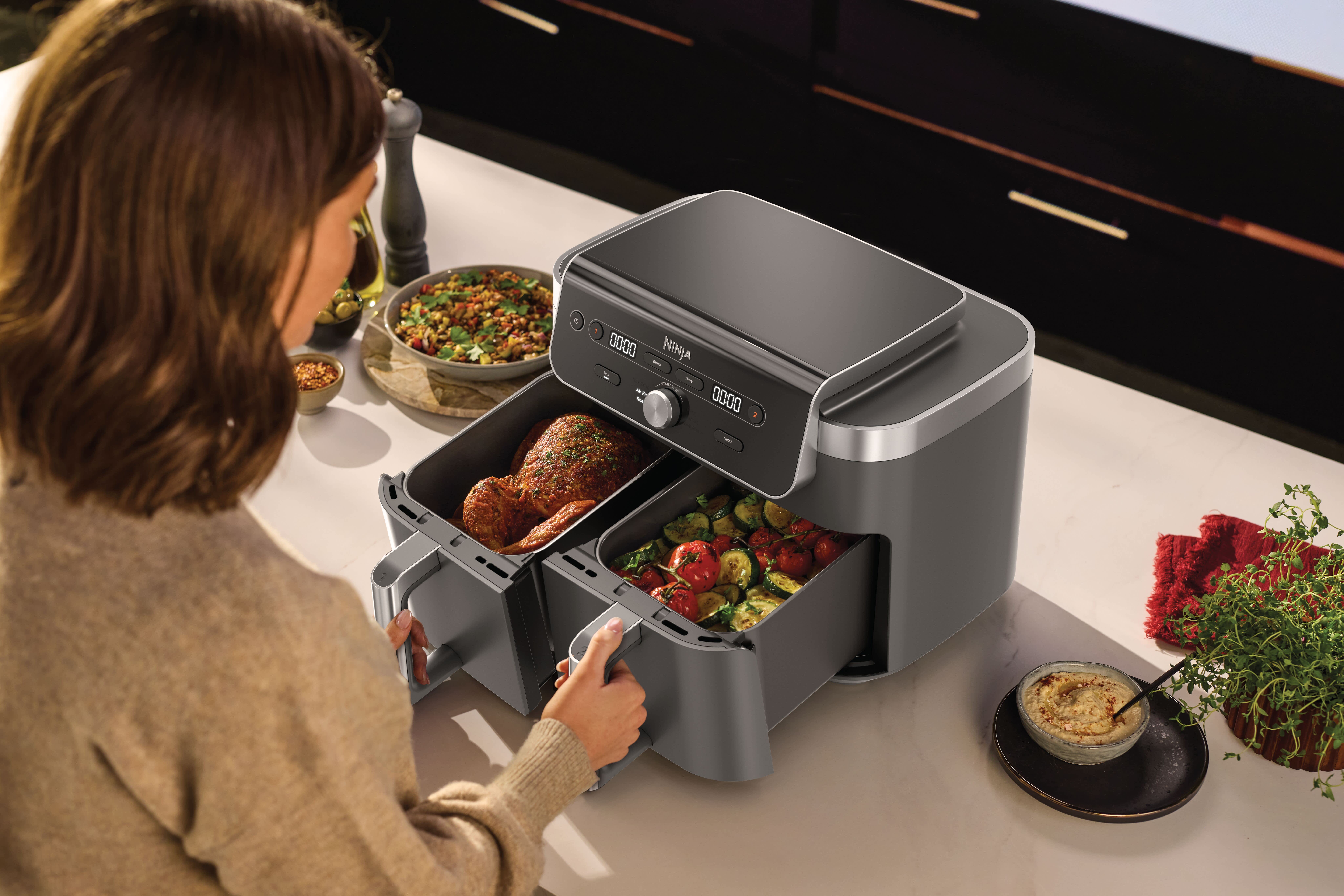 Personne cuisinant de la viande et des l&eacute;gumes dans l'air fryer.