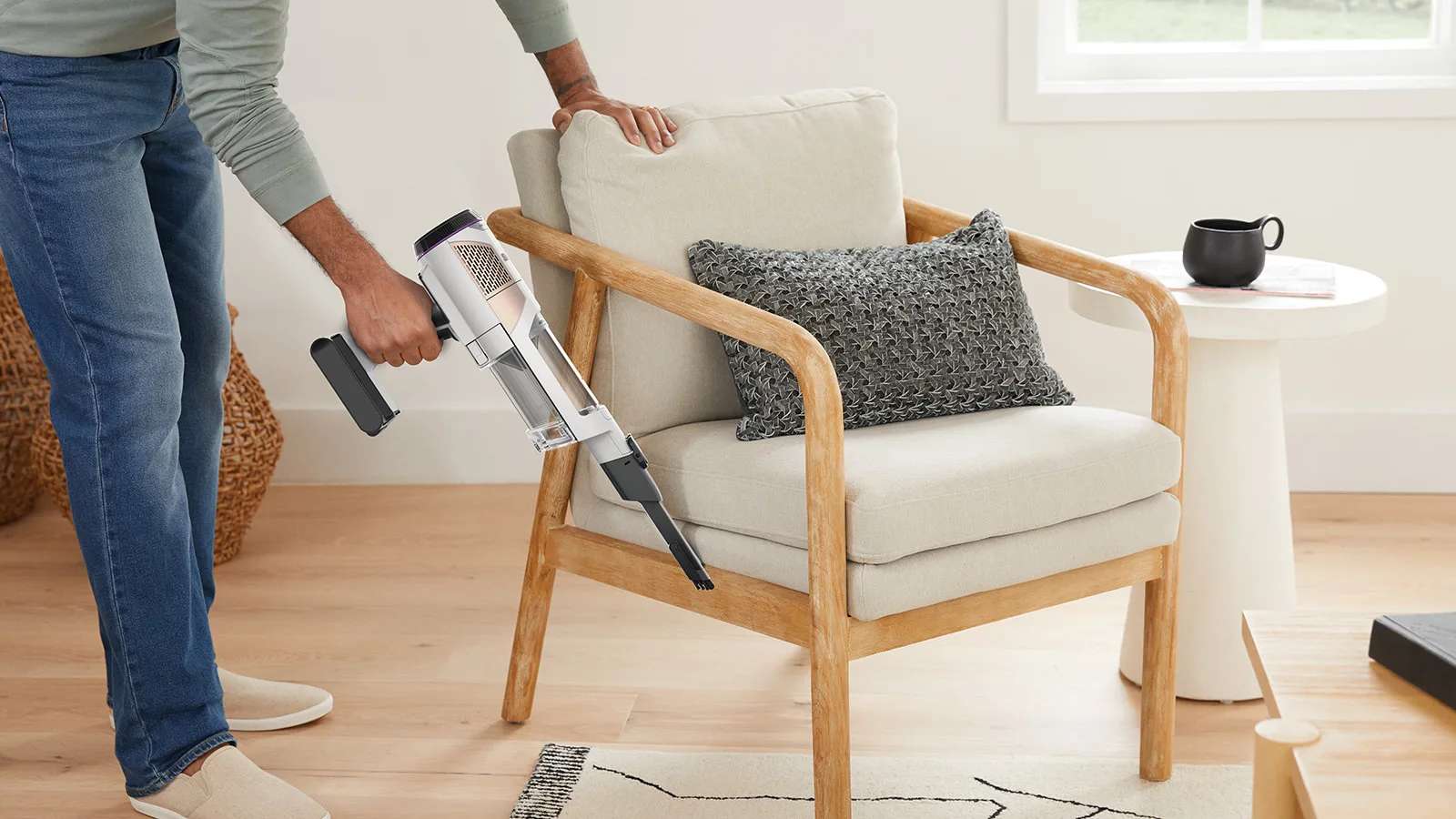 Personne utilisant l&rsquo;aspirateur sans fil en mode &agrave; main sur une chaise.