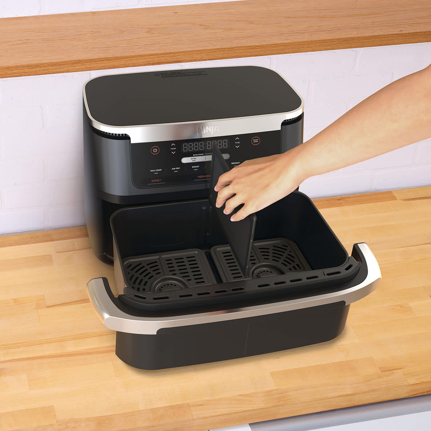 Personne ins&eacute;rant un s&eacute;parateur dans le tiroir de l'air fryer.