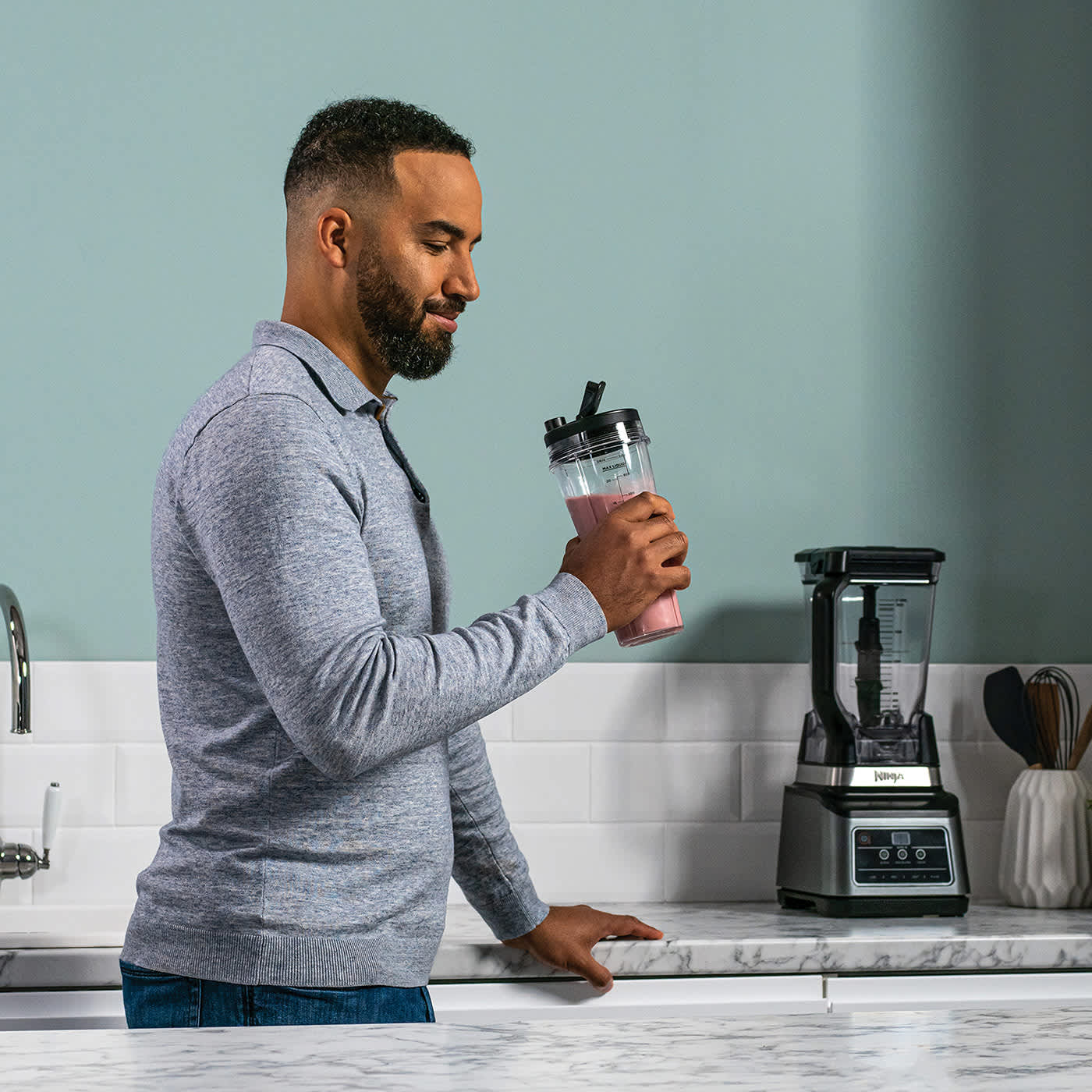 Homme buvant un smoothie pr&eacute;par&eacute; avec le blender Ninja.
