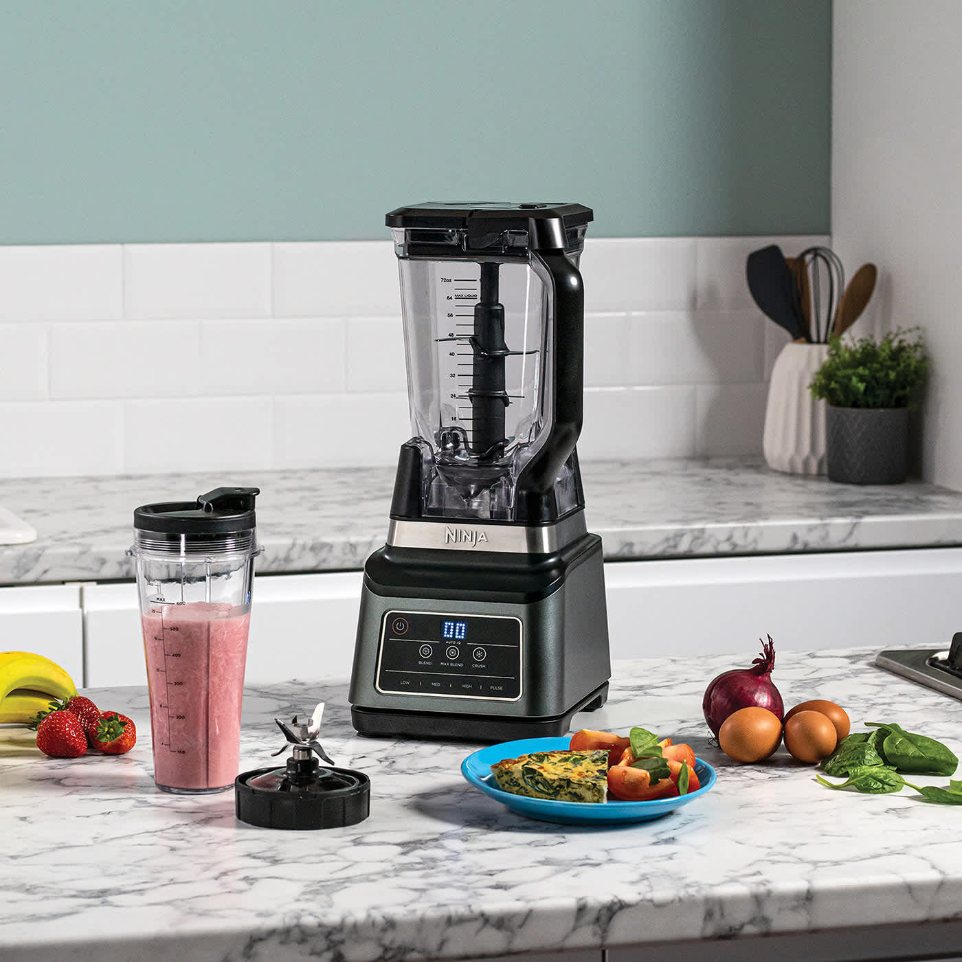 Blender Ninja entour&eacute; d&rsquo;une assiette de nourriture et d&rsquo;un smoothie.