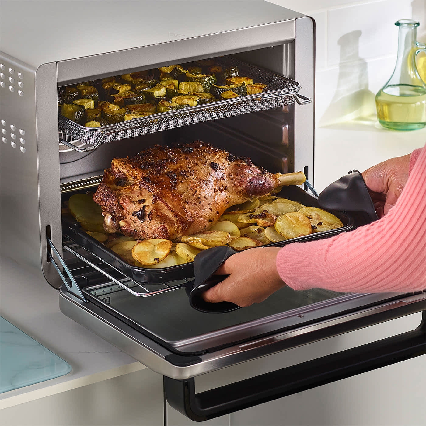 Personne cuisinant de la viande dans un mini four multifonction.