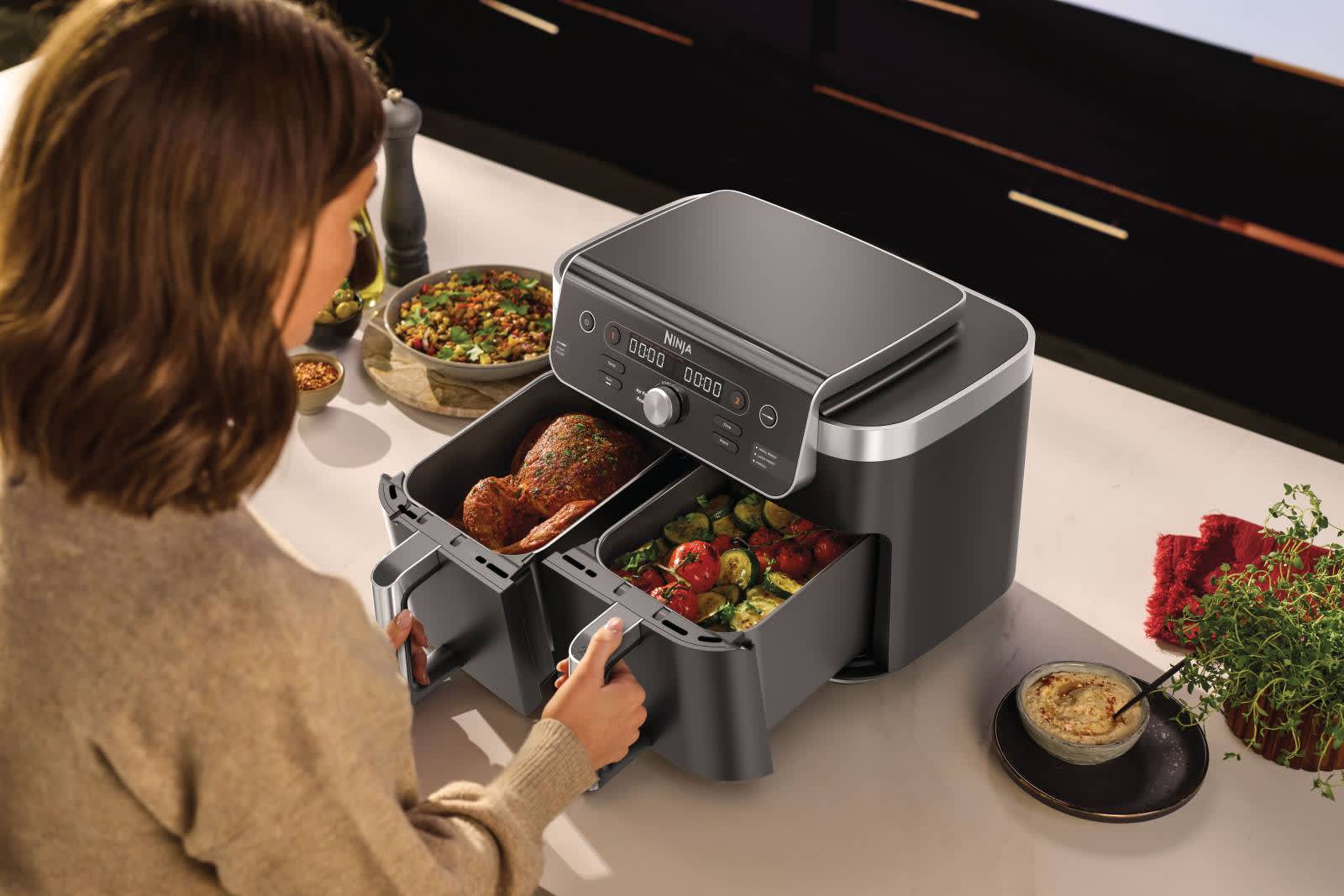 Femme cuisant un poulet entier avec des l&eacute;gumes dans l&rsquo;Airfryer.