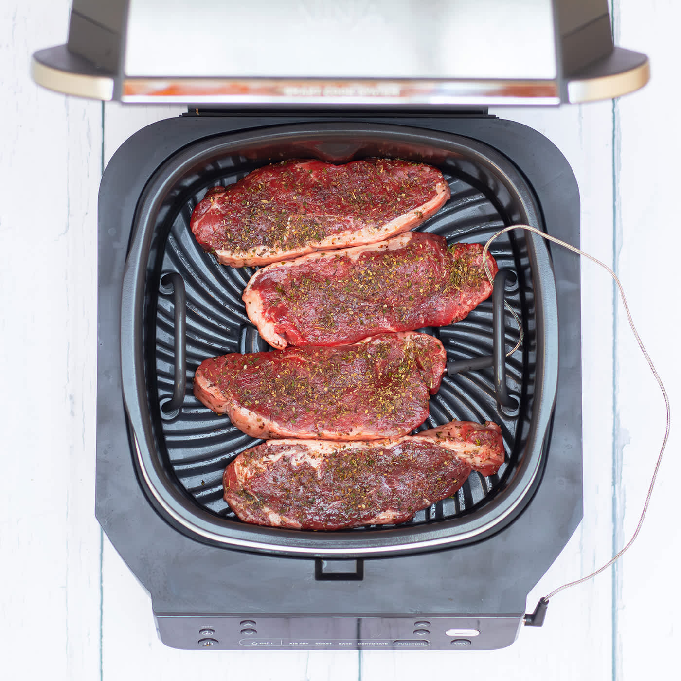 Steak en cours de cuisson dans le grill et l&rsquo;Airfryer Ninja, avec thermom&egrave;tre.