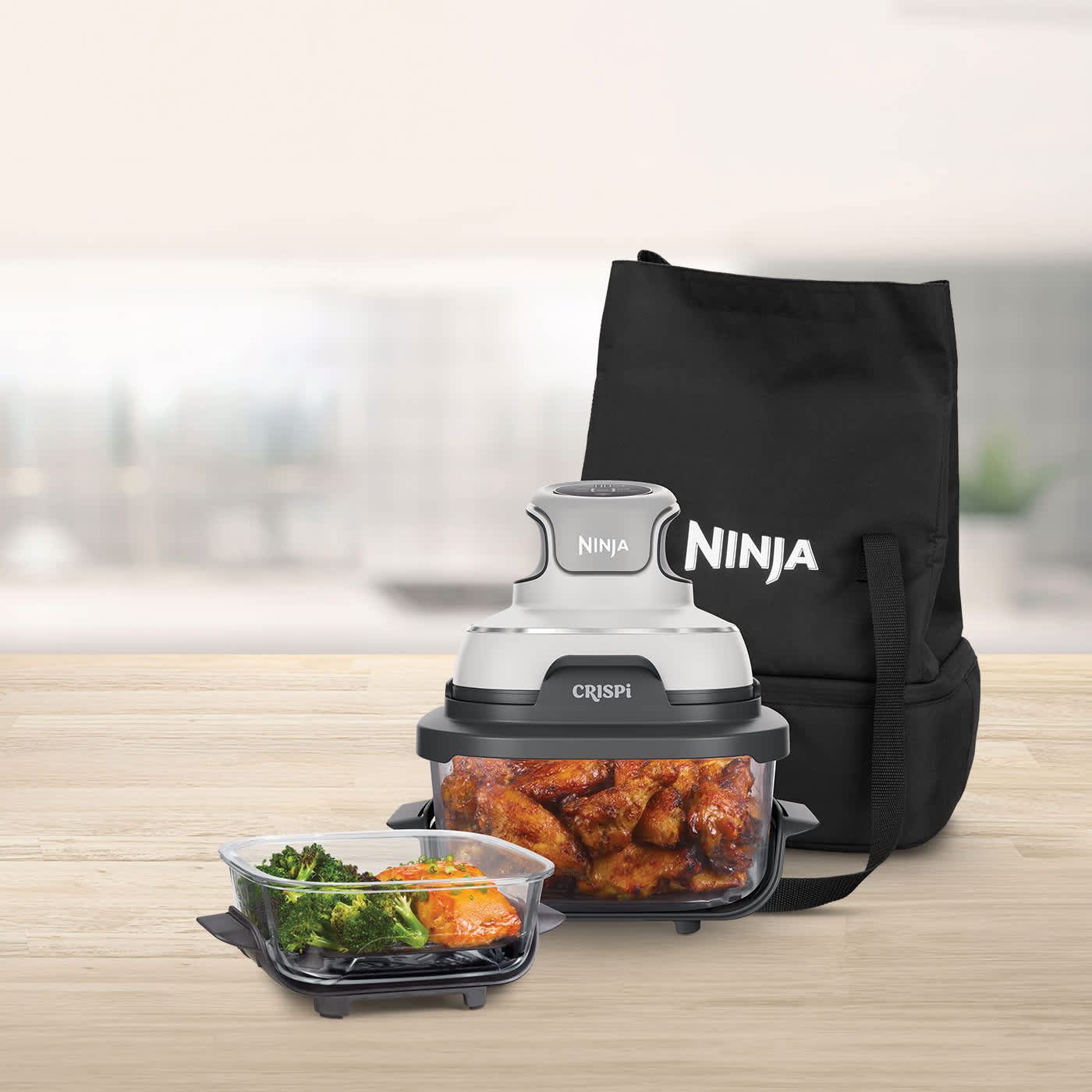 Ninja Crispi contenant du poulet, avec un sac de transport derri&egrave;re et un plat de nourriture devant.