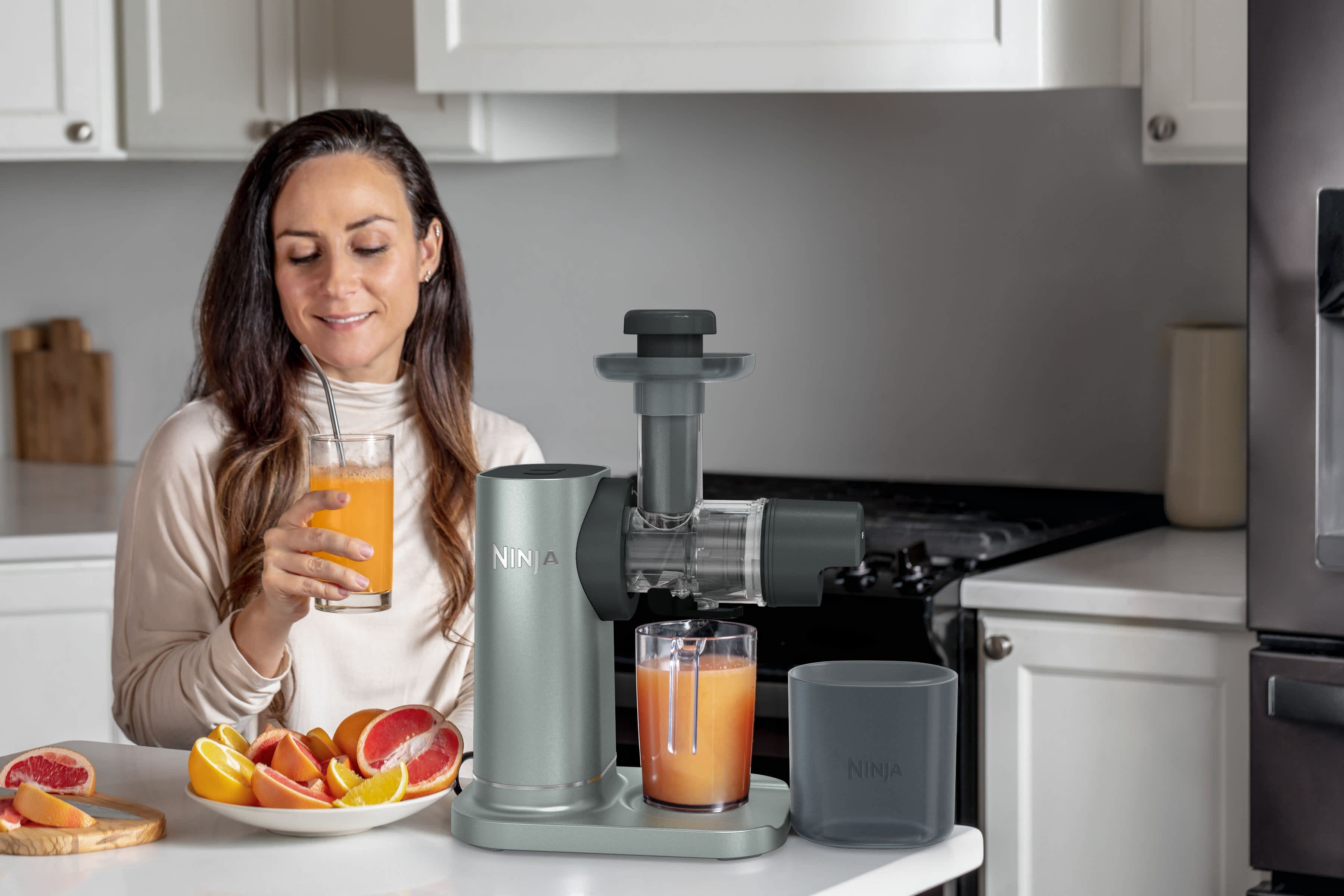 Airfryer pos&eacute; sur une table, entour&eacute; de plusieurs assiettes de nourriture, notamment du poisson et un g&acirc;teau.