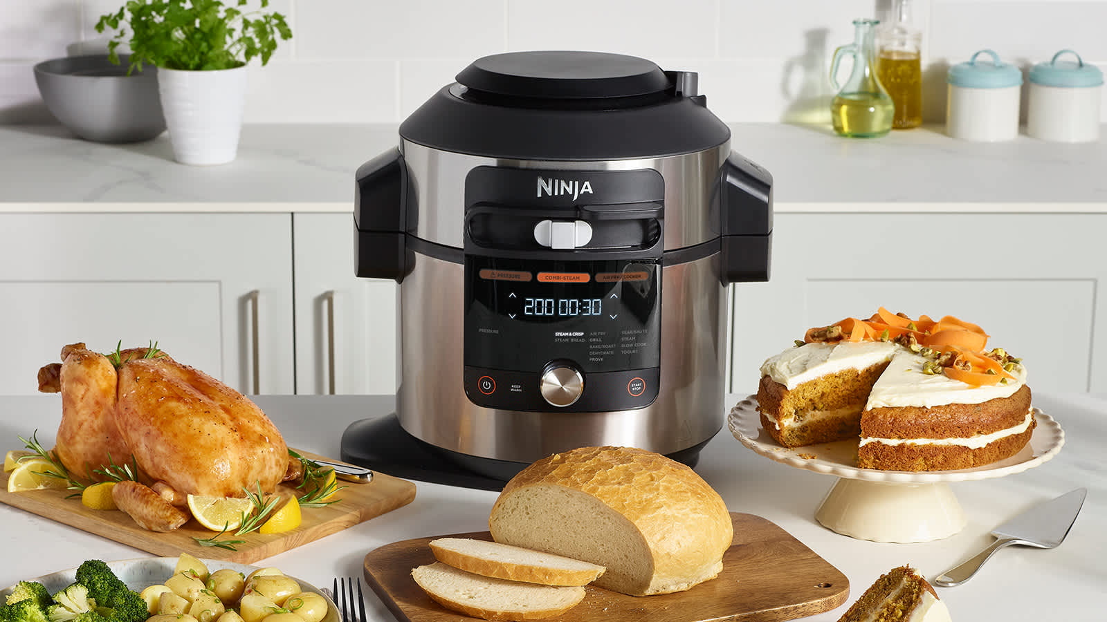 Multicuiseur Ninja pos&eacute; sur une table, avec des assiettes de nourriture &agrave; c&ocirc;t&eacute;.
