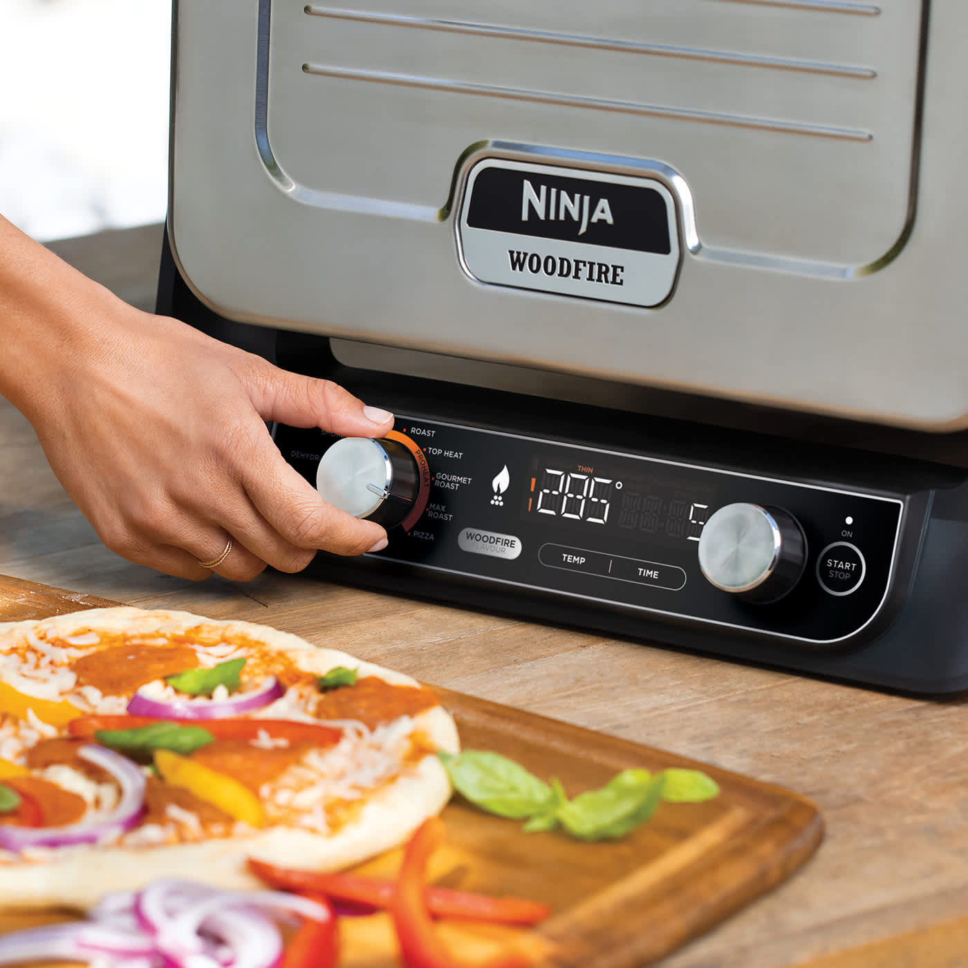 Personne ajustant la temp&eacute;rature du four &eacute;lectrique Ninja.