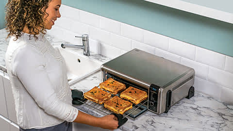 Personne pr&eacute;parant des croque-monsieur dans le mini four Ninja.