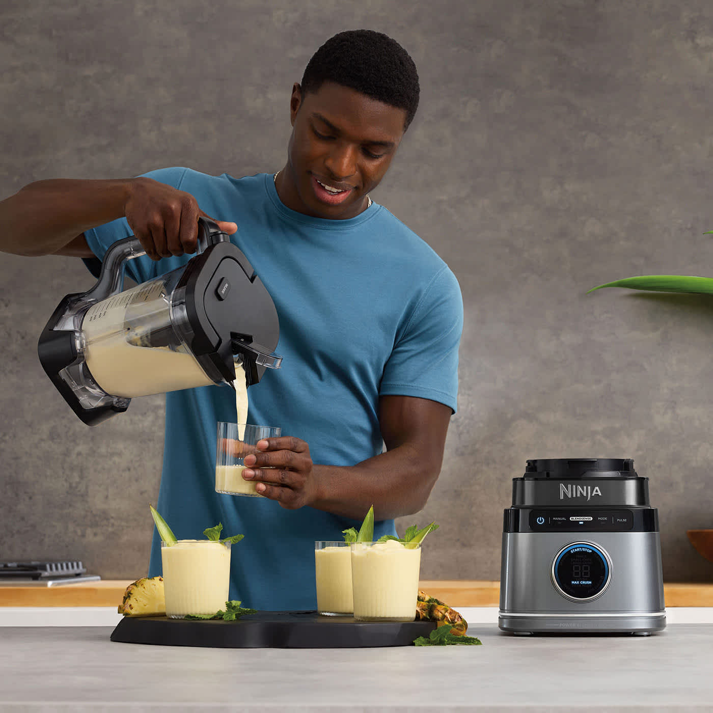 Homme qui verse un smoothie de son blender