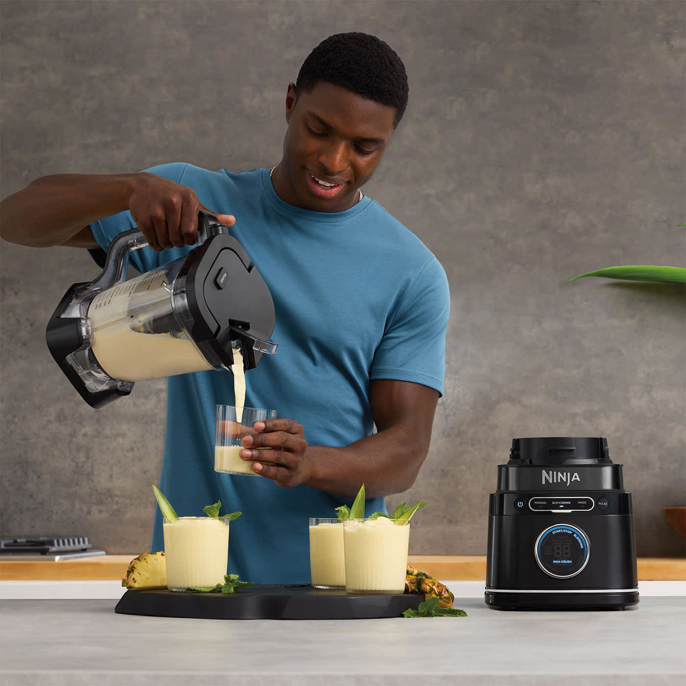 Homme versant des smoothies du blender Ninja dans des gobelets.