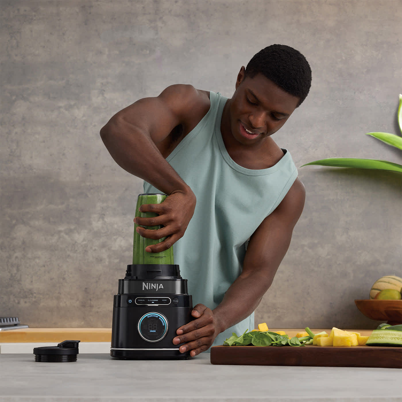 Homme fixant un gobelet sur le blender Ninja.