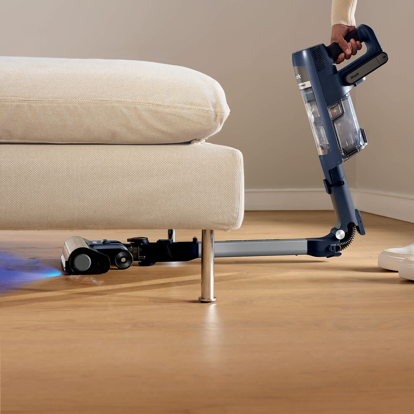 Aspirateur sans fil passant sous un meuble
