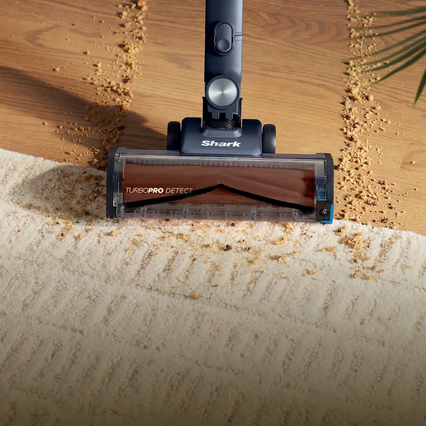 Aspirateur sans fil nettoyant un amas de salet&eacute;s.