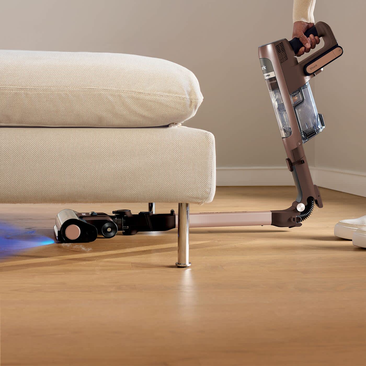 Aspirateur sans fil passant sous un meuble