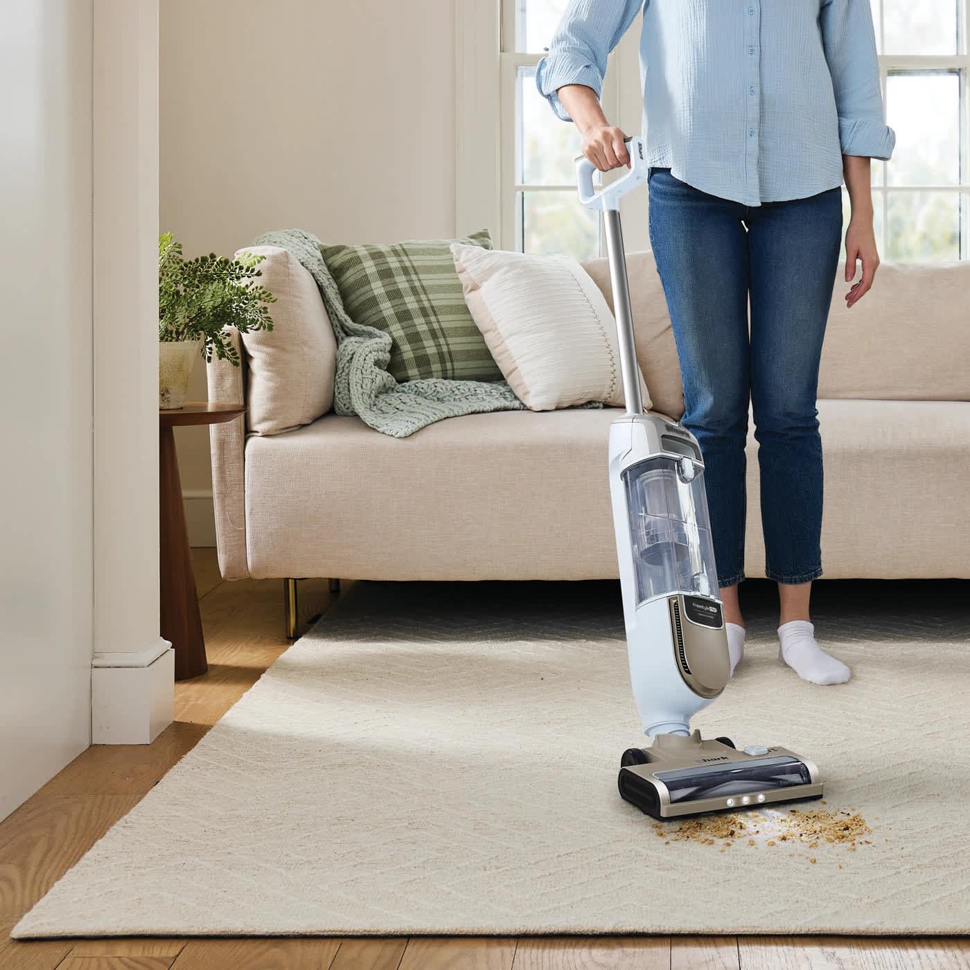 Personne aspirant la salet&eacute; d'un tapis avec l'aspirateur sans fil Ninja.