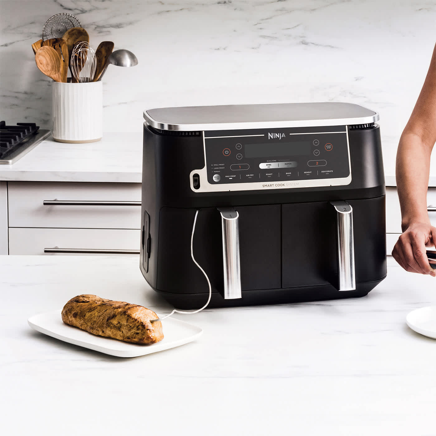 Ninja Air Fryer auf K&uuml;chenzeile neben Fleisch mit Thermometer.