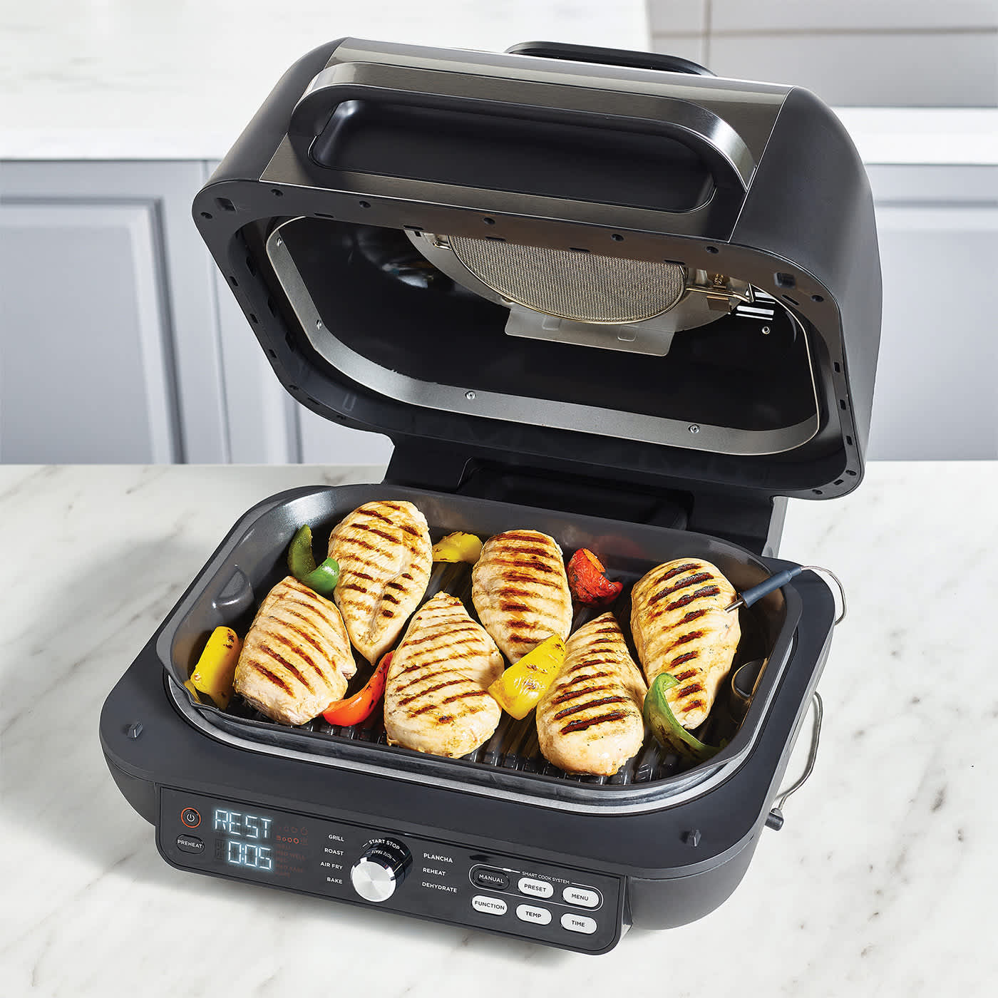 Draufsicht auf die ge&ouml;ffnete Grillfl&auml;che des Ninja Foodi Max Pro mit mehreren Steaks und Grillgem&uuml;se