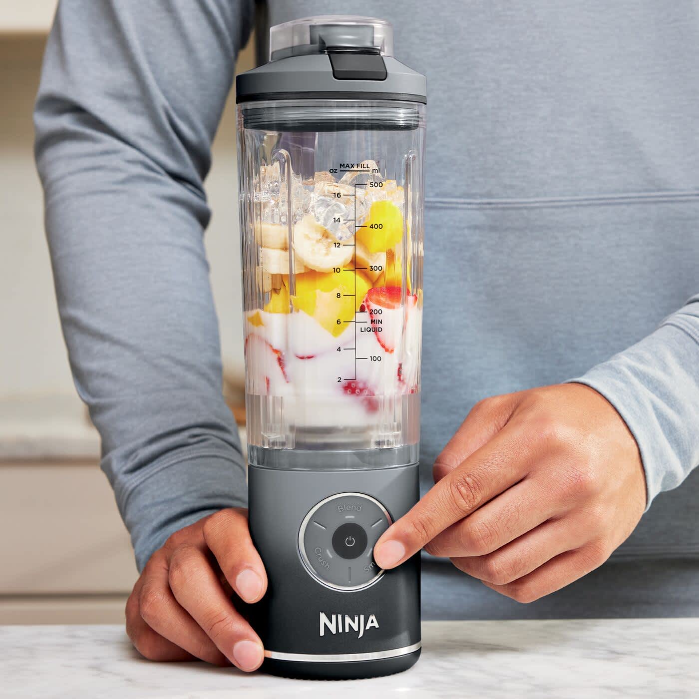 Personne appuyant sur les boutons du blender portable Ninja.