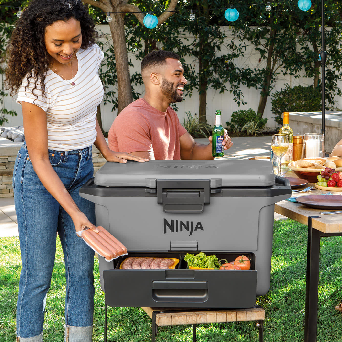 Person &ouml;ffnet die Schublade der Ninja FrostVault K&uuml;hlbox mit Essen, Box steht auf einer Bank