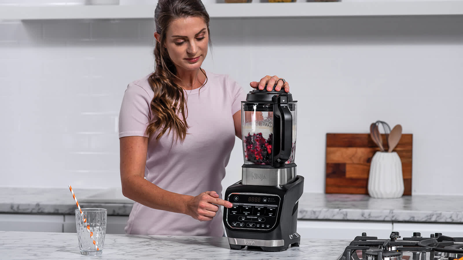 Femme pr&eacute;parant un smoothie dans le blender.