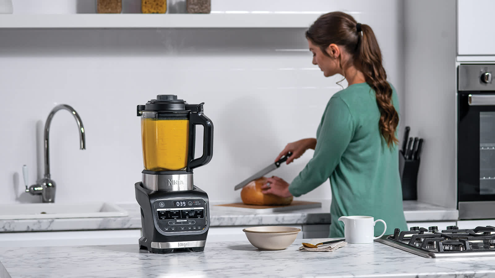 Femme pr&eacute;parant une soupe avec le blender Ninja.