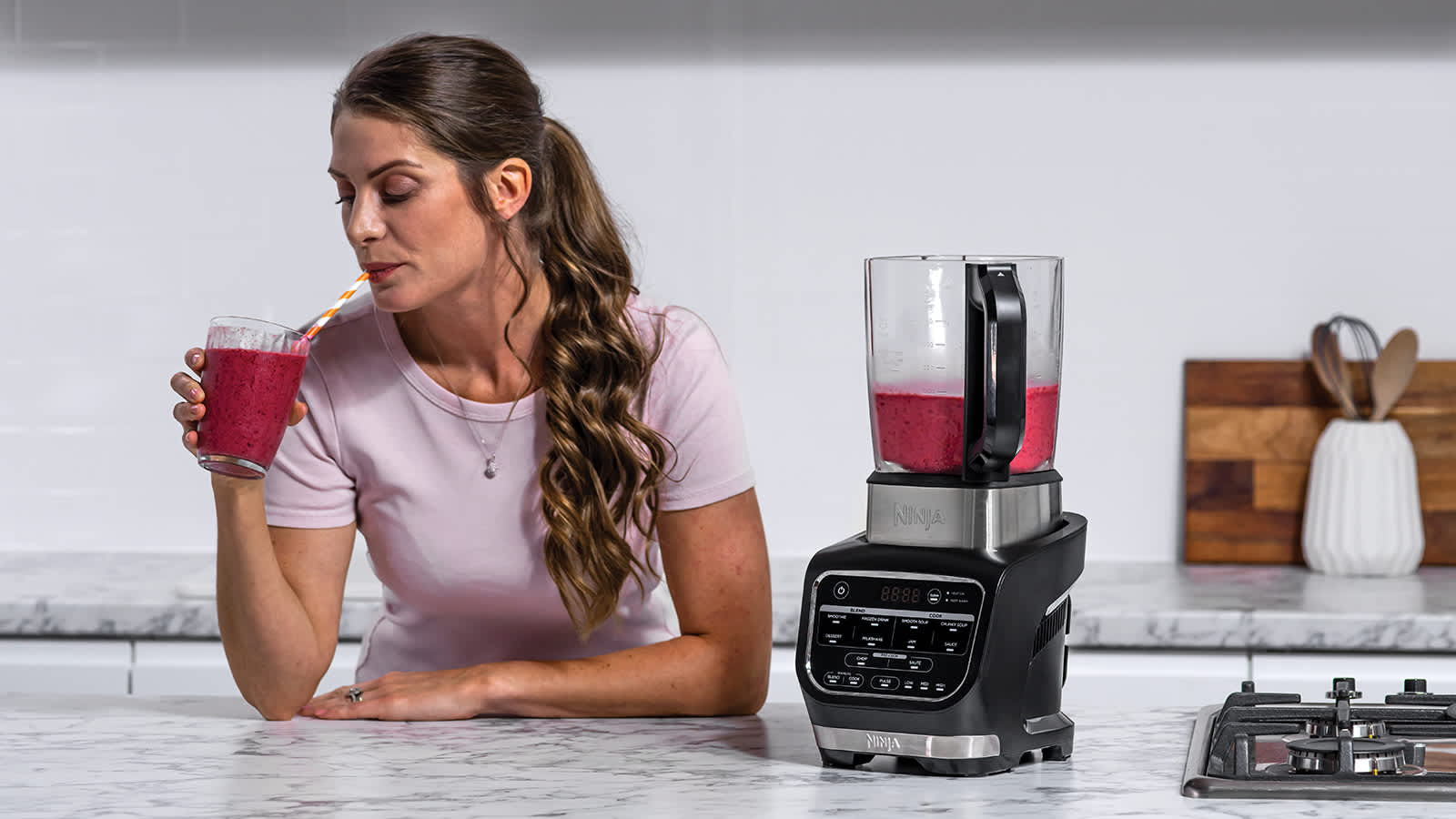 Femme buvant un smoothie pr&eacute;par&eacute; avec le blender.