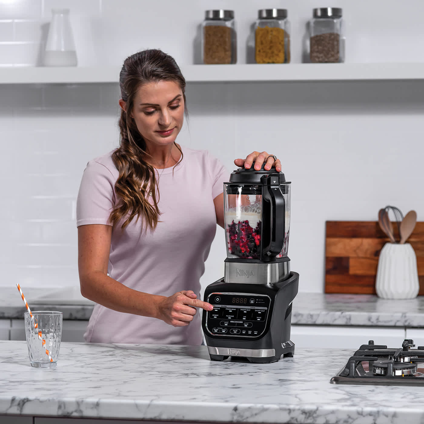 Femme pr&eacute;parant un smoothie dans le blender.
