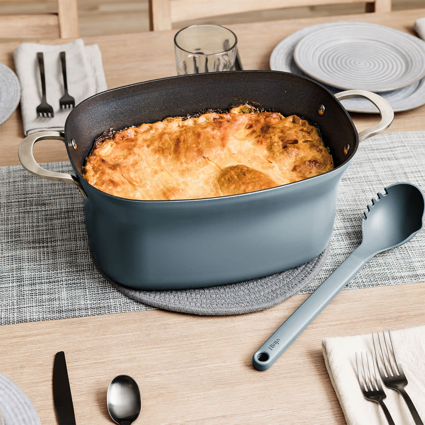 Gratin im backofenfesten Ninja Foodi Topf wird auf dem Esstisch serviert.