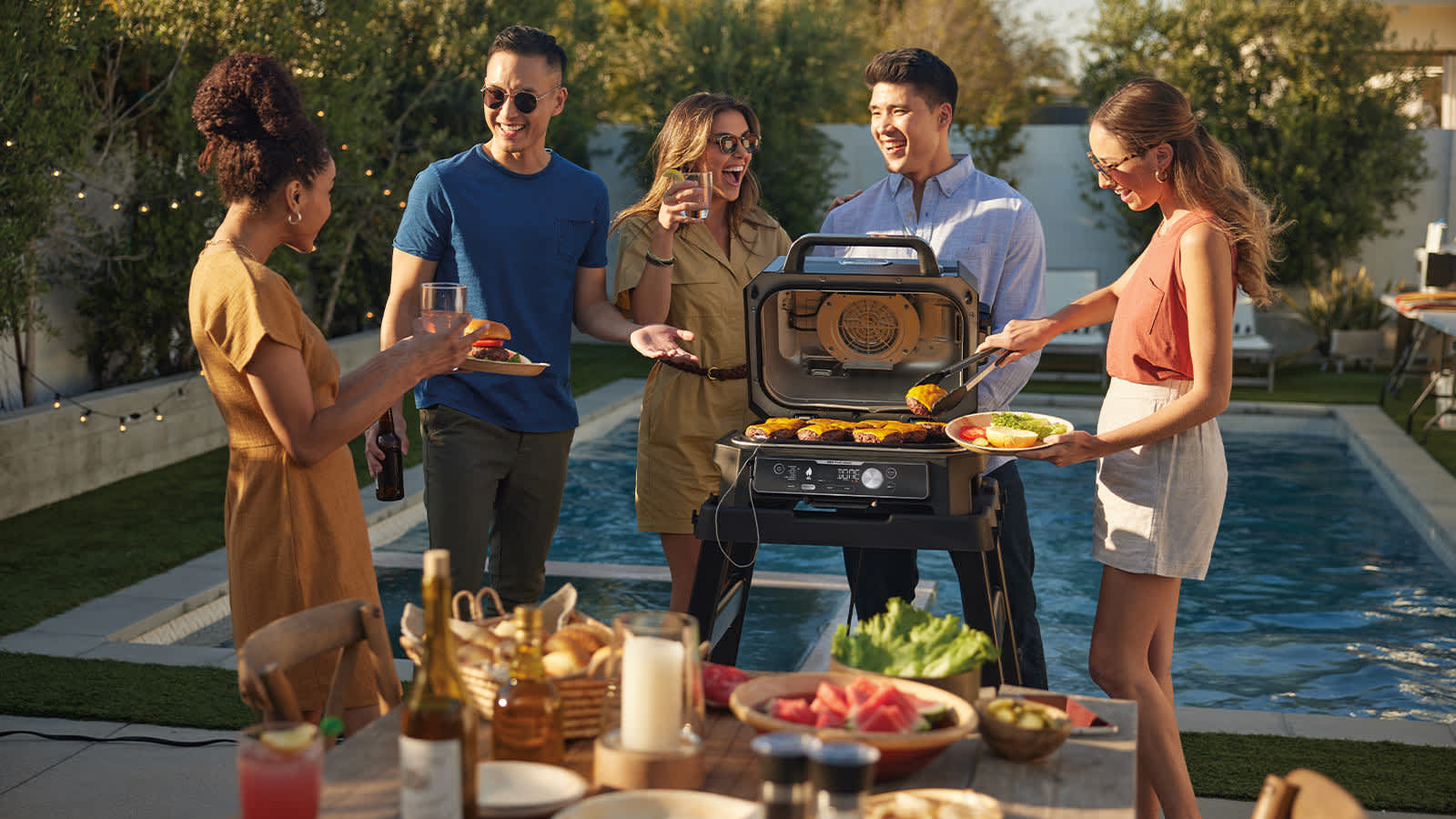 Personnes autour du barbecue Ninja en train de griller.