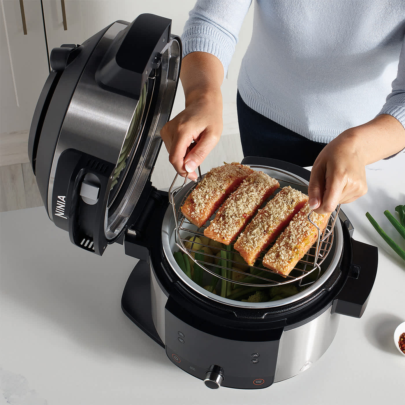 Einsetzen des Grillrost-Einsatzes in den Ninja Foodi 11-in-1 SmartLid Multikocher.