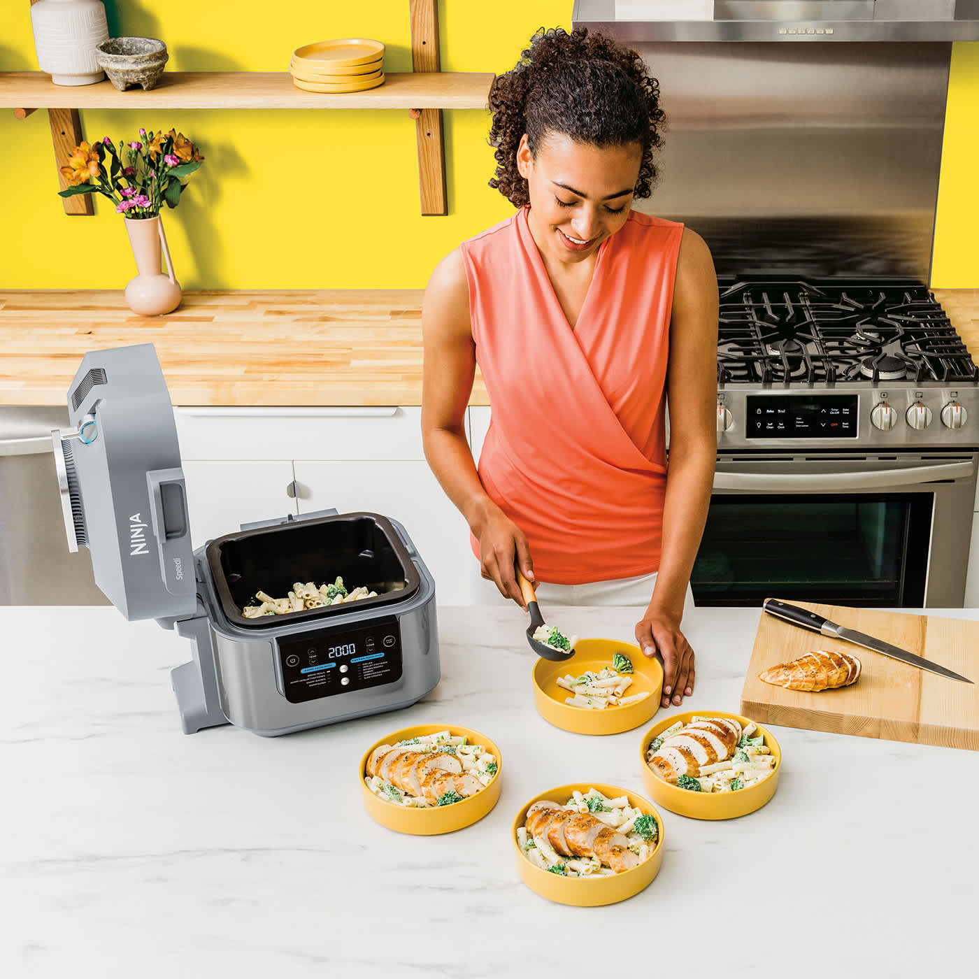 Person serviert frisches Essen aus dem Ninja Speedi Multicooker.