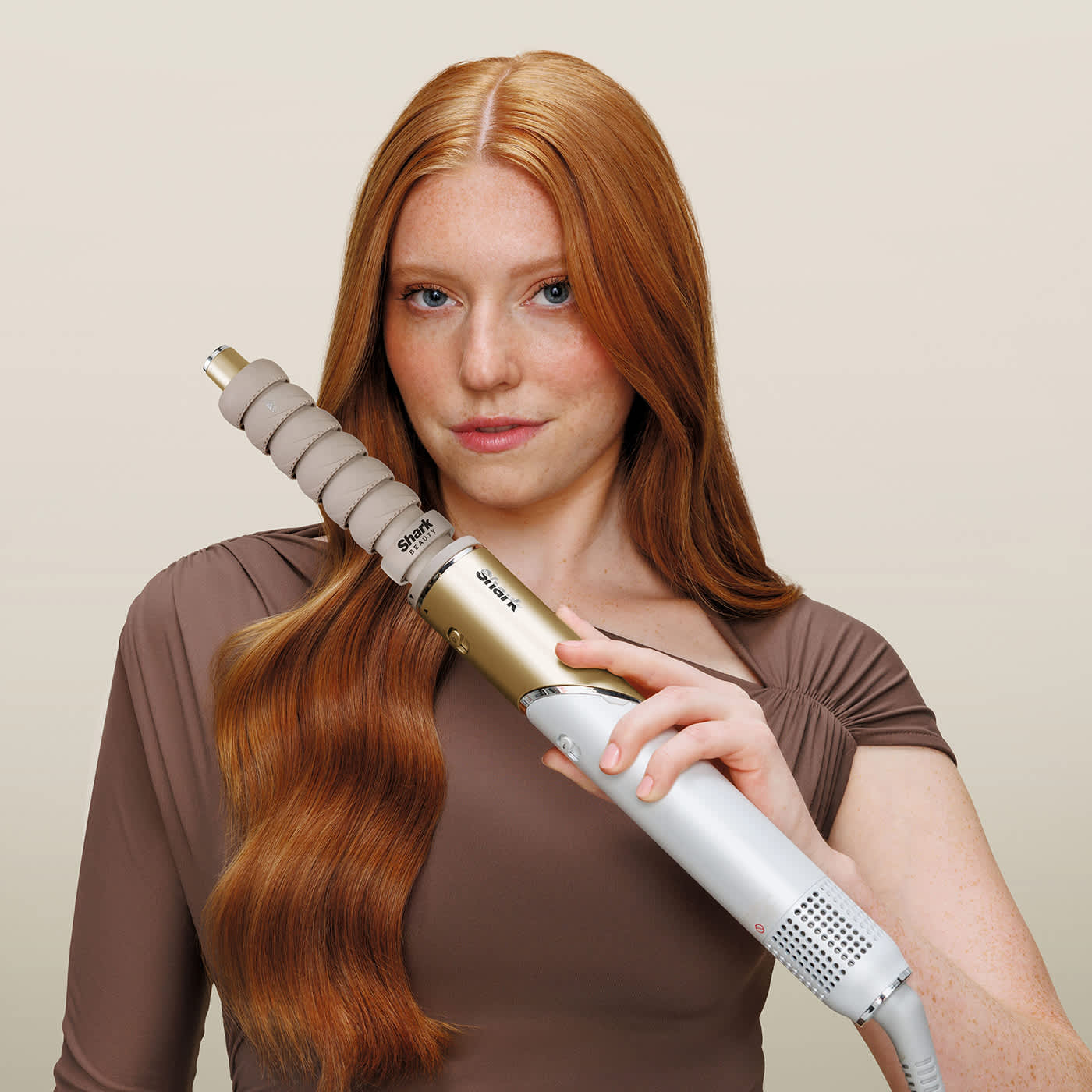 Frau stylt definierte Locken mit dem Glam Auto-Wrap-Lockenaufsatz durch Coanda-Luftstrom-Technologie.