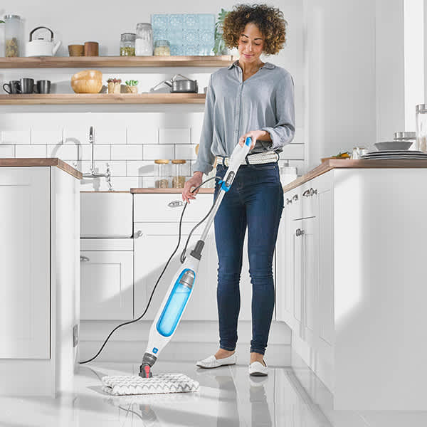 Person benutzt den Klik n' Flip S6001EU Dampfreiniger zum Putzen des K&uuml;chenbodens