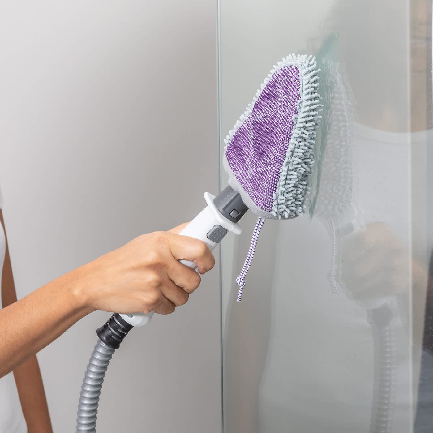 Dampfreiniger reinigt Glasoberfl&auml;che im Badezimmer hygienisch und streifenfrei.