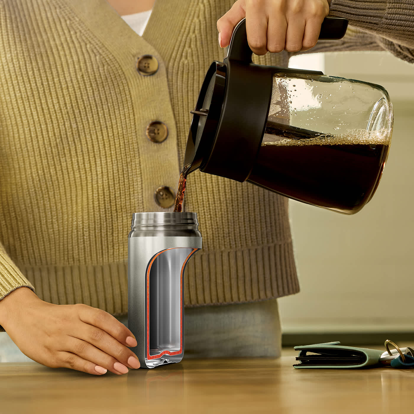 Eine Person gie&szlig;t sich Kaffee in den Ninja SipPerfect Trinkbecher ein.