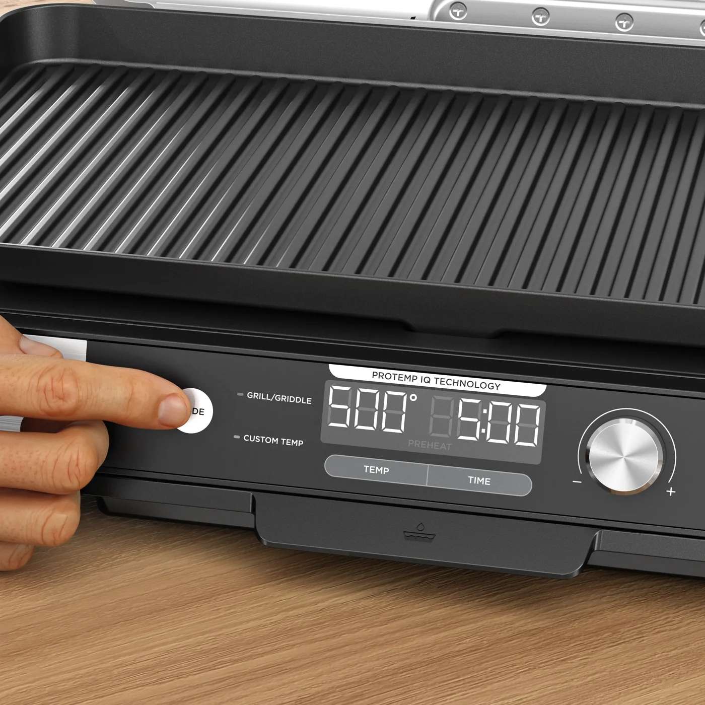 Eine Person stellt den Ninja Sizzle Pro XL &uuml;ber das Bedienfeld ein