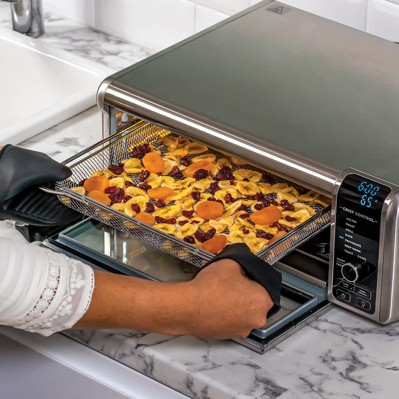 Ninja Foodi 8-in-1 Mini-Ofen mit Fr&uuml;chten und Snacks im Frittierkorb &ndash; kompakt und platzsparend.