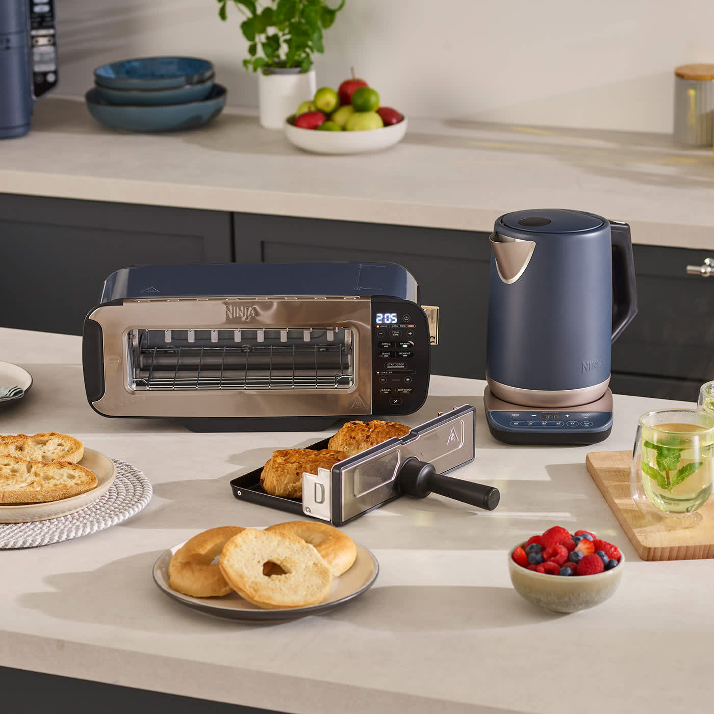Toaster und Wasserkocher auf der K&uuml;chenzeile mit Brot und Obst und Gem&uuml;se.