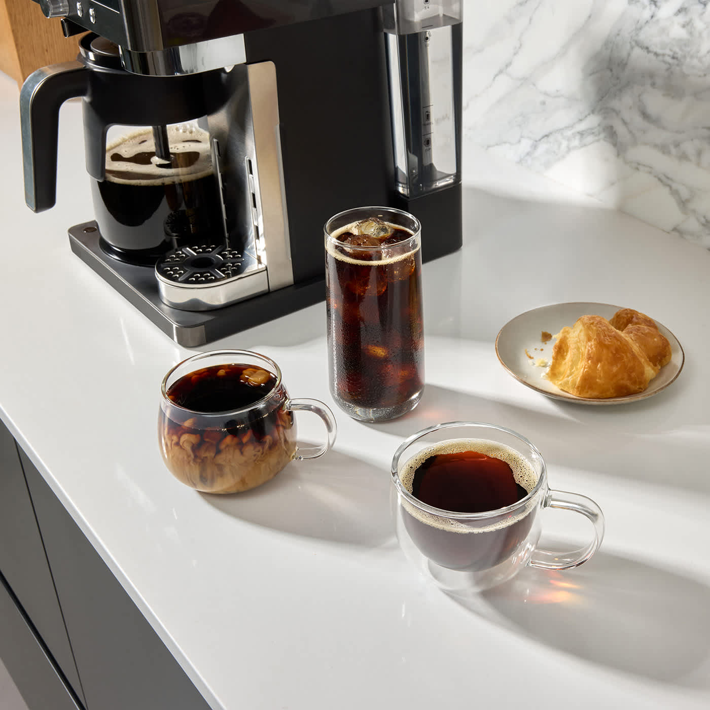 Macchina da caff&egrave; Filtro e Capsule Ninja Prestige DualBrew con diverse bevande al caff&egrave; intorno