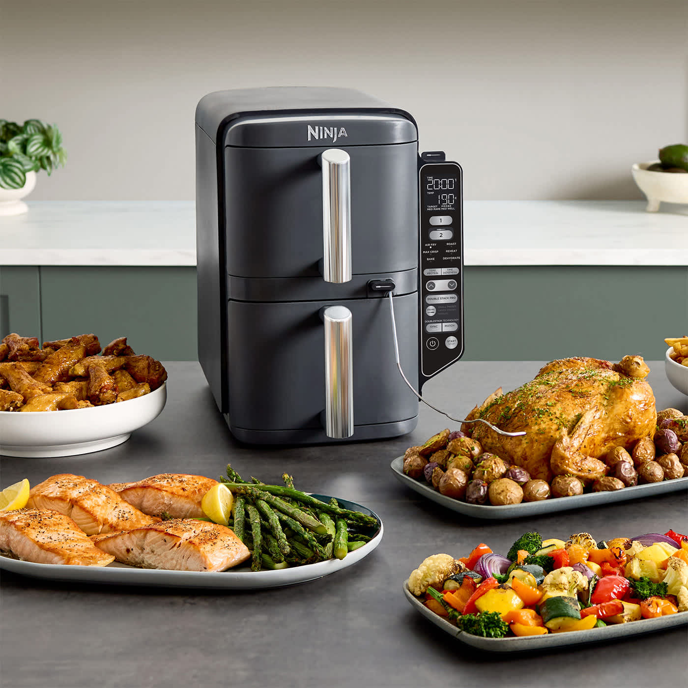 Air fryer Ninja entour&eacute; de plats de nourriture.