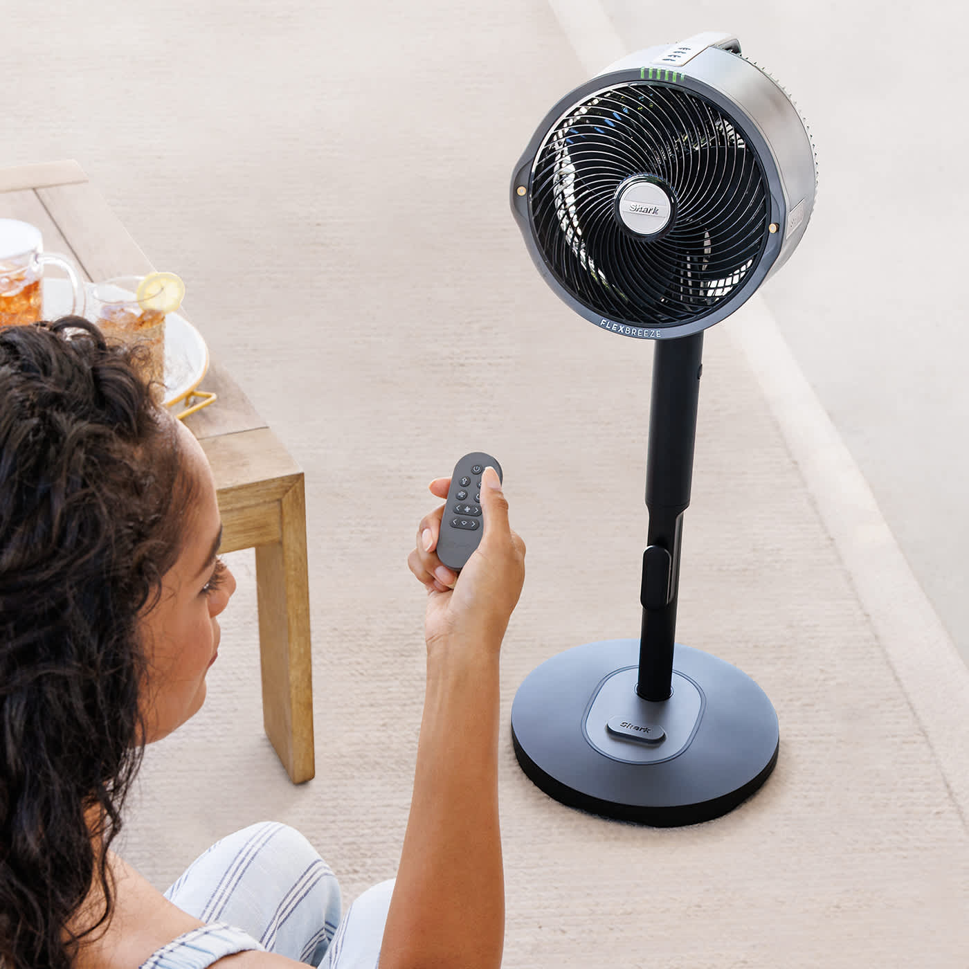 Immagine di una donna che usa il telecomando del Ventilatore Shark FlexBreeze Pro Mist