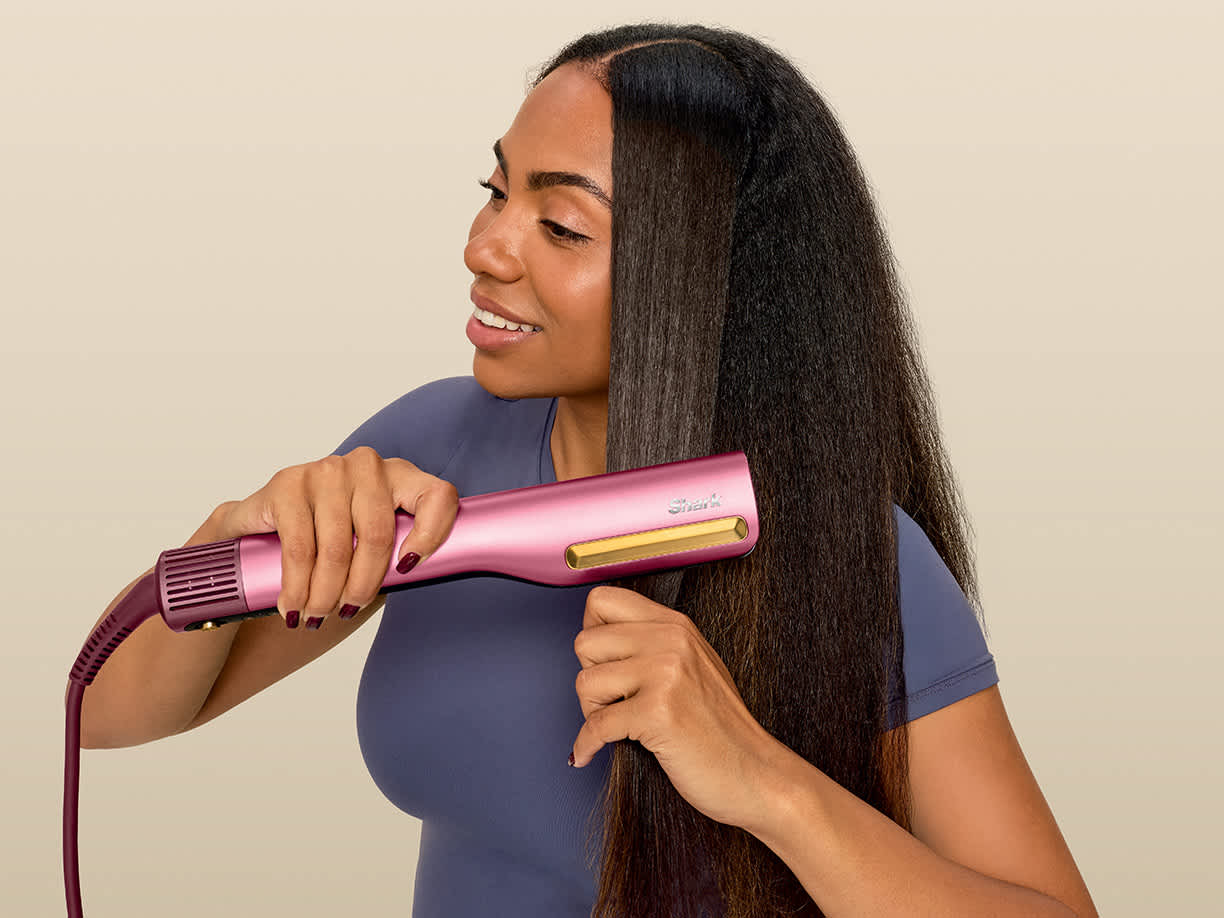 Ragazza molto riccia che ottiene capelli lisci perfetti con la piastra Shark SilkiPro