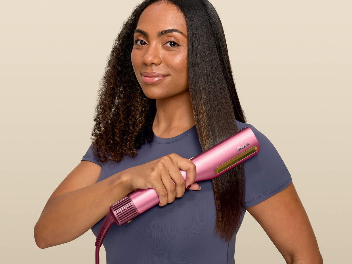 Ragazza che si liscia i capelli con la piastra Shark SilkiPro