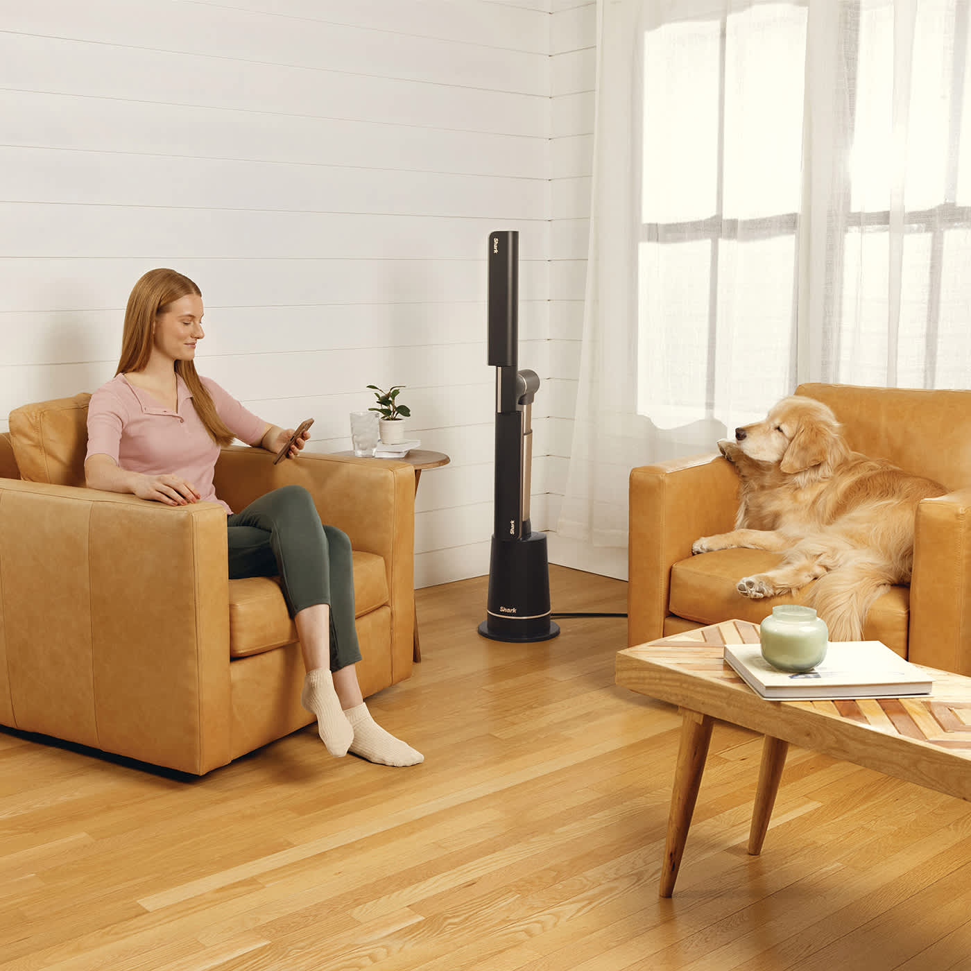 Immagine del ventilatore Shark Turboblade che rinfresca un soggiorno con una donna e un cane
