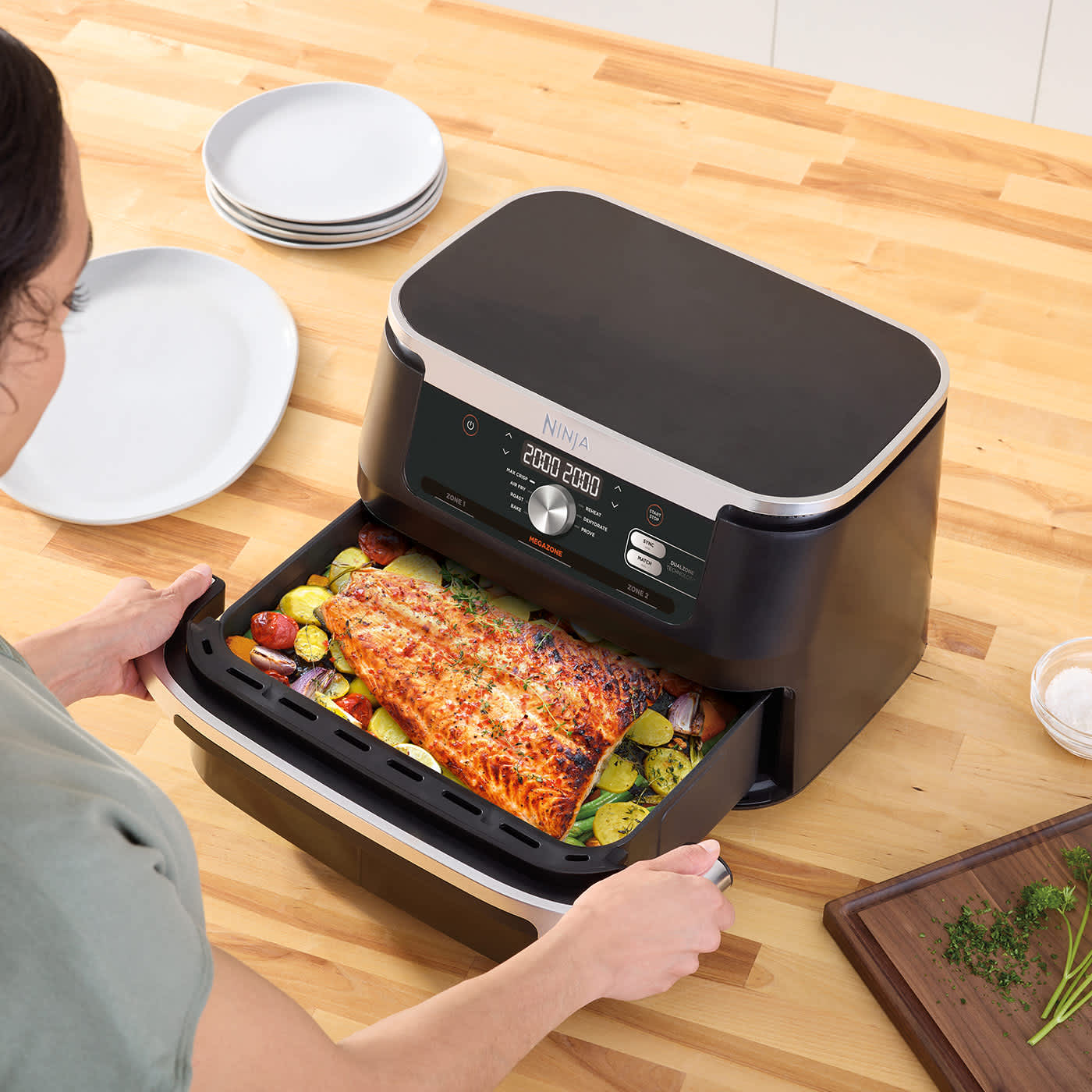 Immagine di una friggitrice ad aria Ninja FlexDrawer senza divisorio con dentro un grande pesce con verdure